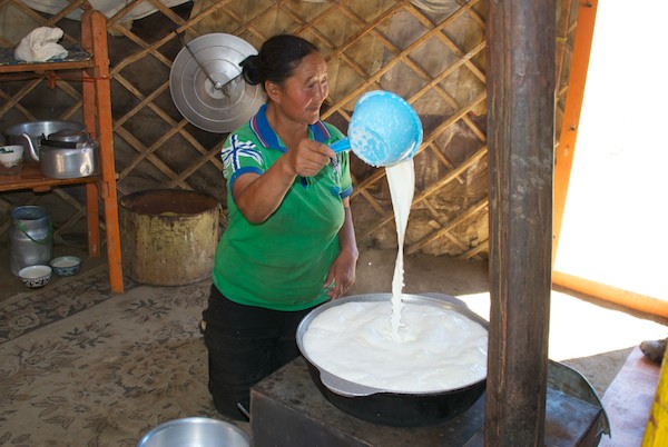 She is heating fresh milk so it will separate the cream.
