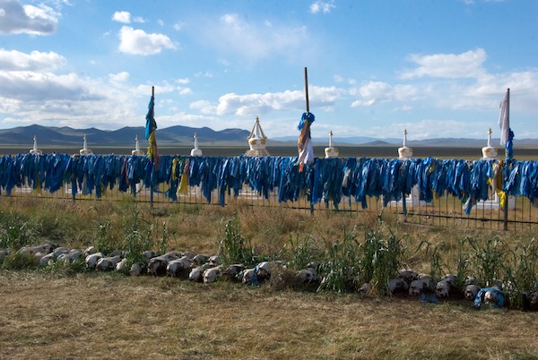 Behind the "temple" was this extraordinary sight- a fence utterly covered with khadag and, on the ground, hundreds of horses skulls. On the plain in the background is where we had camped.