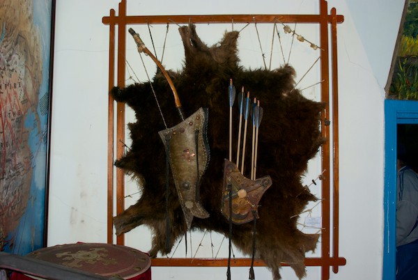 Traditional archery equipment mounted on a bearskin rug.