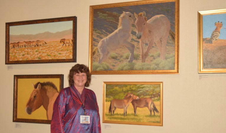Susan Fox poses with some of her paintings